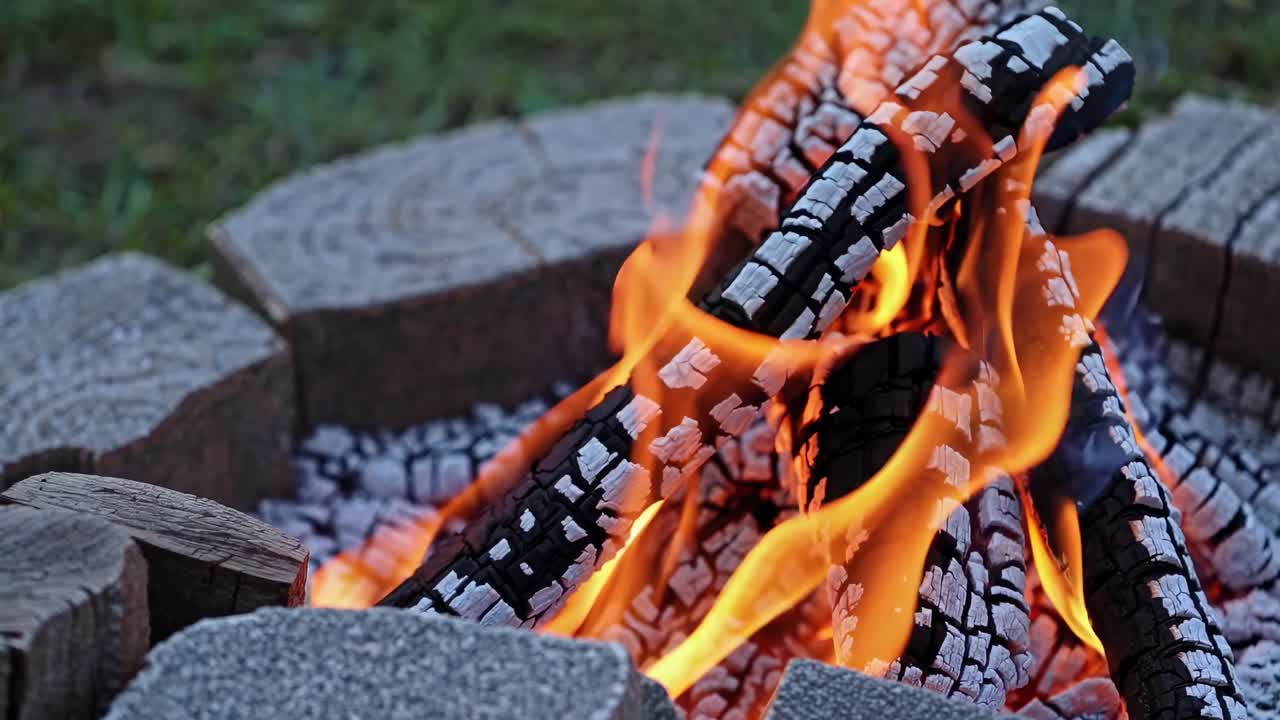 Close-up video of a campfire with logs burning, captured from a low angle