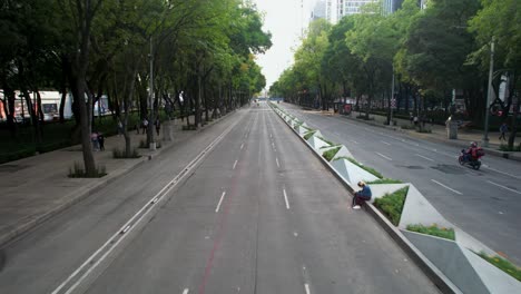 drone-shot-from-the-front-of-a-sunset-on-the-paseo-de-la-reforma-in-mexico-city-while-two-motorcyclists-circulate-along-it