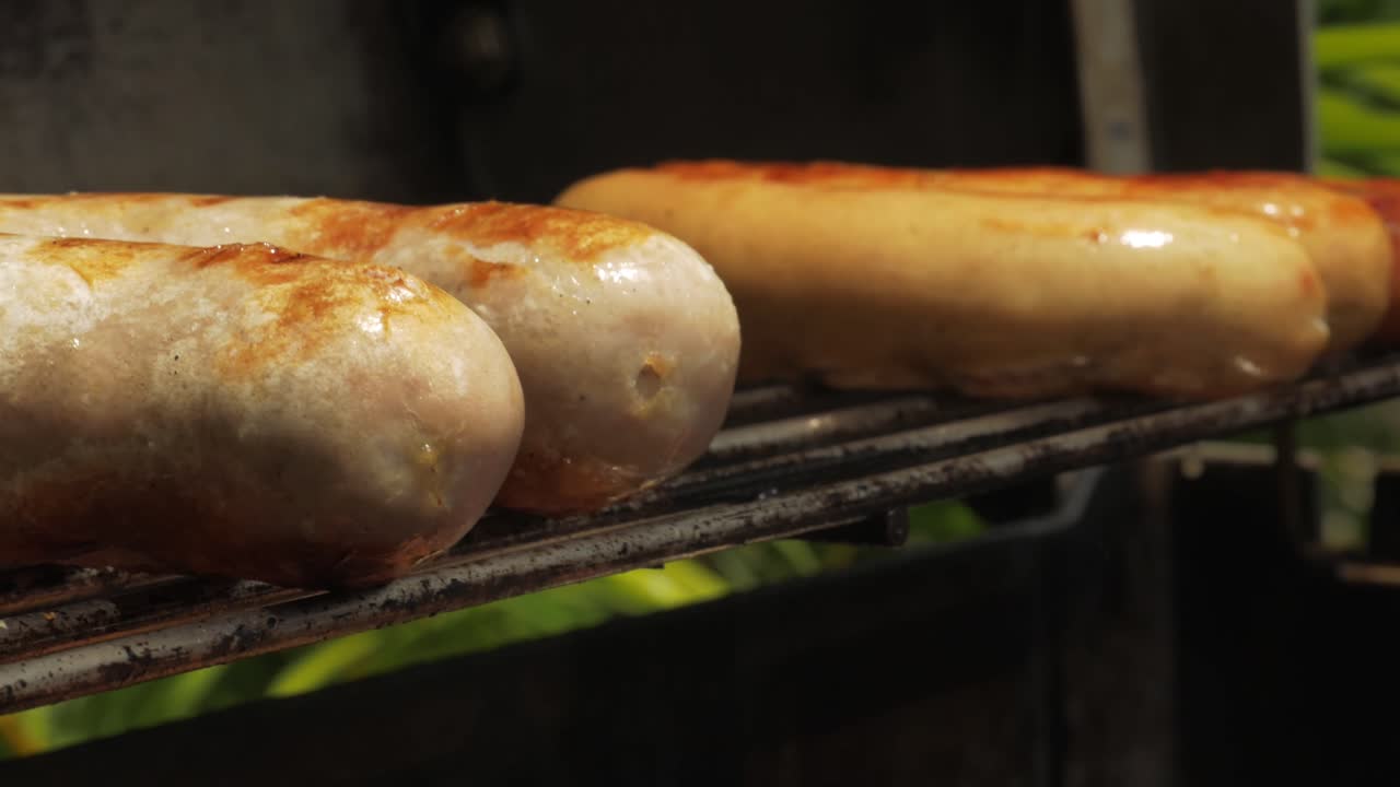 barbacoa día soleado salchichas comida a la parrilla hombres colocando salchichas en el fuego de la barbacoa cocina cruda