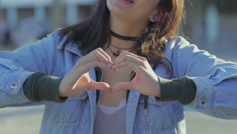 closeup shot of teen girl making heart shape with hands