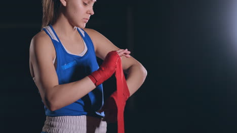 Tiro-Medio.-Hermosa-Boxeadora-Envuelve-Vendas-Rojas-En-Las-Manos.-Disparo-De-Cámara-Steadicam