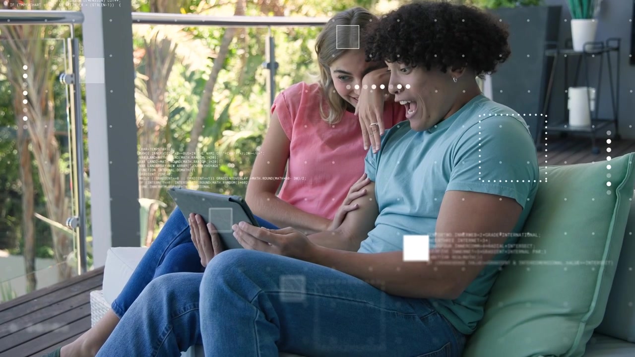Man tapping tablet, woman leaning on balcony sofa, initiating animated tech charts around screen