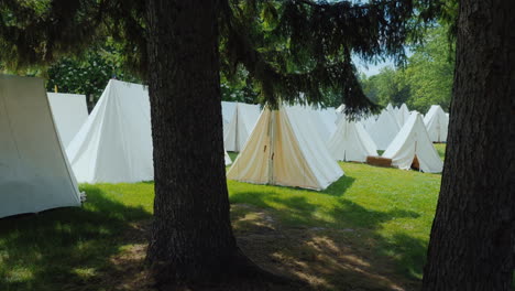 An-Old-Military-Camp-Rows-Of-Tents-Stand-In-The-Forest-Reconstruction-Of-The-Times-Of-The-Wars-With