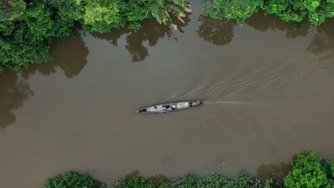 aerial top down shot of boat cruising over amazon river in south america during cloudy day