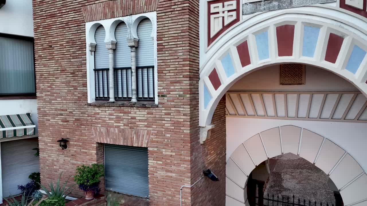 Spanish Architecture: Brick Building with Moorish Archway and Gate
