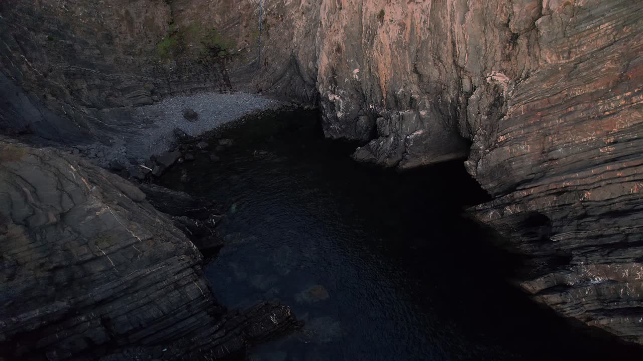 Vista dettagliata di ripidi strati di falesie sedimentarie stratificate a Cabo Sardão nel Parco Naturale della Costa Vicentina, camper sulla falesia.