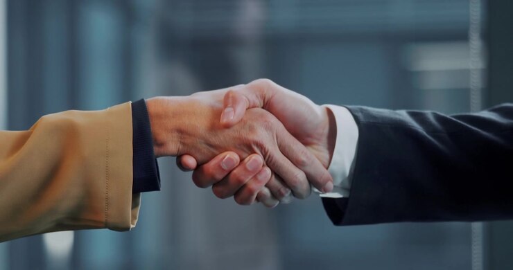 Professionisti d'affari che si stringono la mano in un ufficio moderno