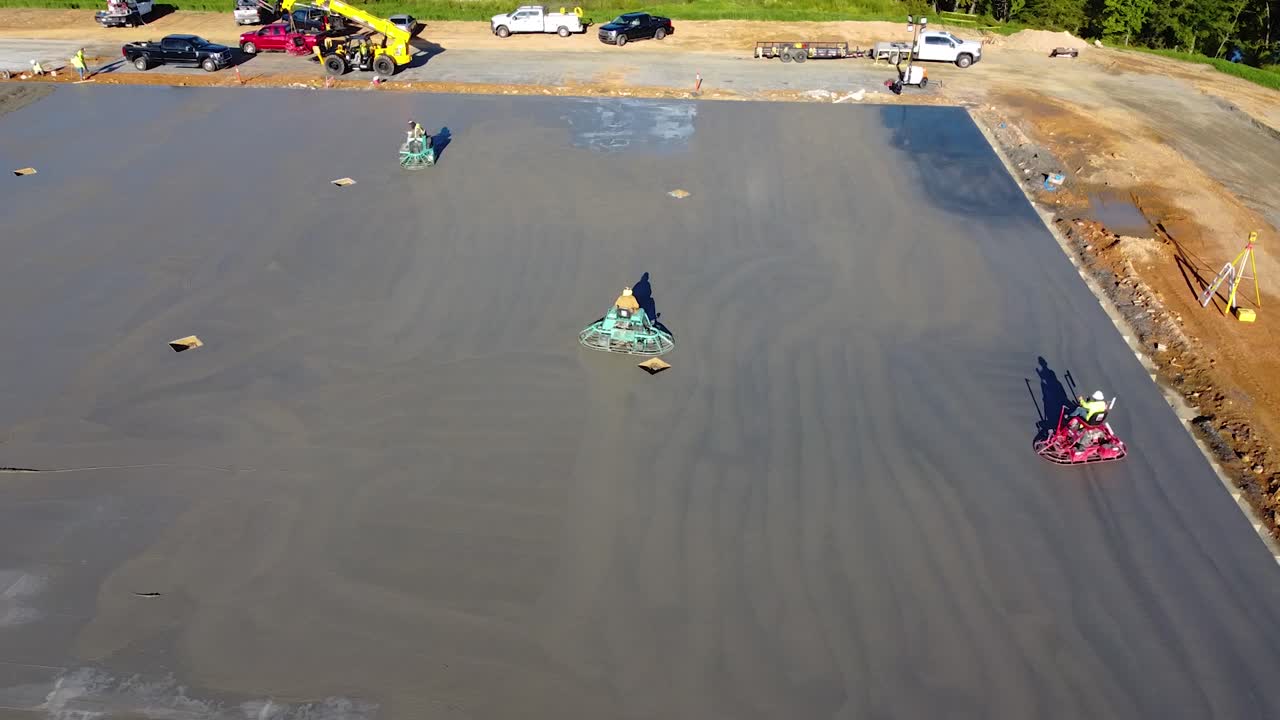 varias paletas grandes pasan sobre el concreto para terminarlo correctamente