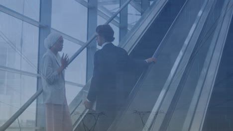 animation of financial data and graphs over diverse businessman and businesswoman on escalator