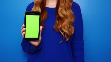 Young-redhead-girl-showing-phone-green-screen-for-social-media-network-application