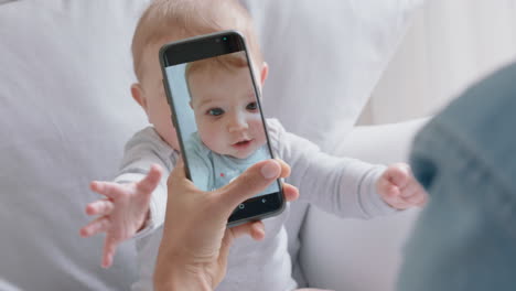 mother taking photo of baby using smartphone enjoying photographing cute toddler sharing motherhood lifestyle on social media