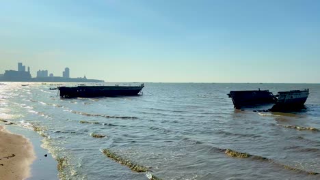 two boats stranded on chonburi's sandy shore