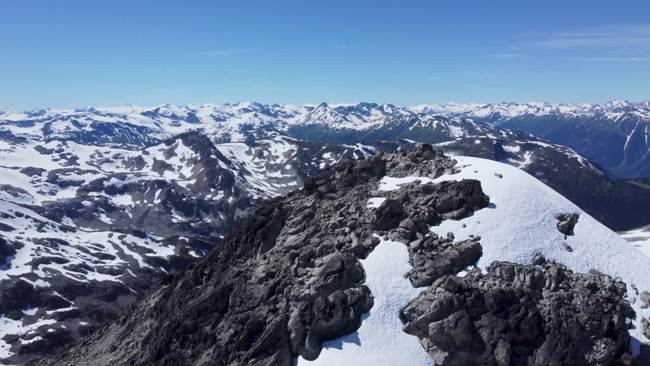 increíble dron aéreo revela disparo desde el pico de la montaña para revelar el paisaje cubierto de nieve pacific ranges canadá bc 4k