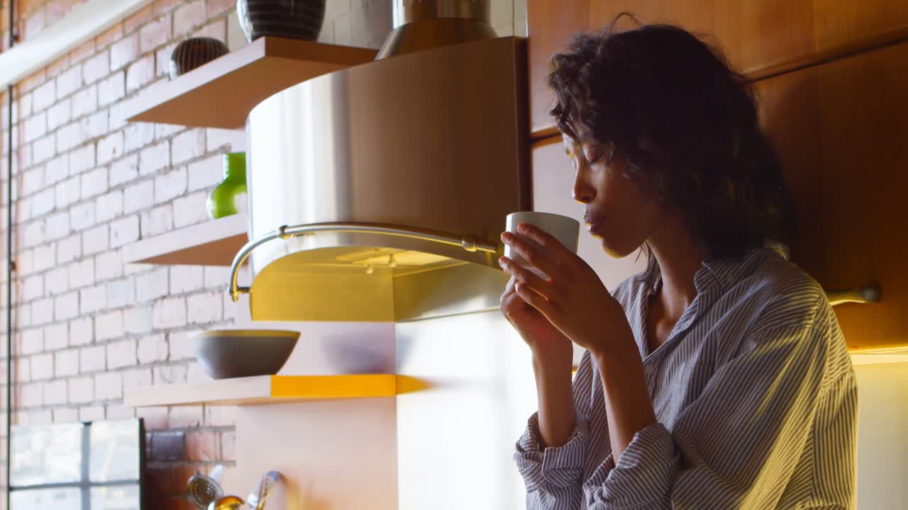 mujer tomando café en la cocina en casa 4k