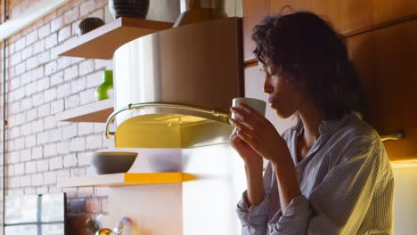 Woman-having-coffee-in-kitchen-at-home-4k