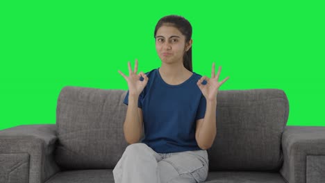 Happy-Indian-teenage-girl-showing-okay-sign-Green-screen