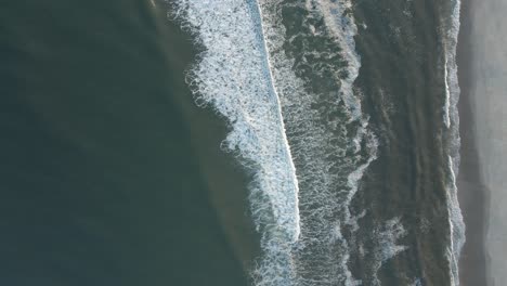 white waves rolling to the sand -aerial top view slowmo