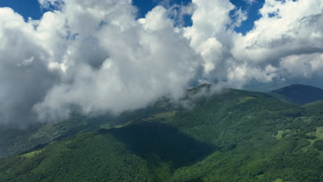 volando a través de nubes blancas y esponjosas por encima de los picos verdes de las montañas