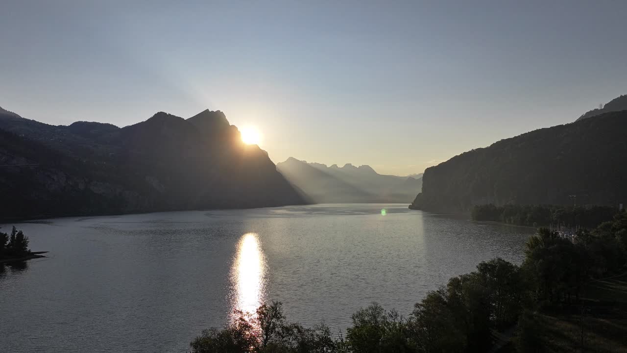 drone de alta velocidade avançando sobre o lago walensee em um pôr-do-sol deslumbrante