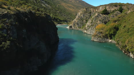 Flight-through-rocky-canyon-over-Kawarau-River,-Queenstown,-New-Zealand