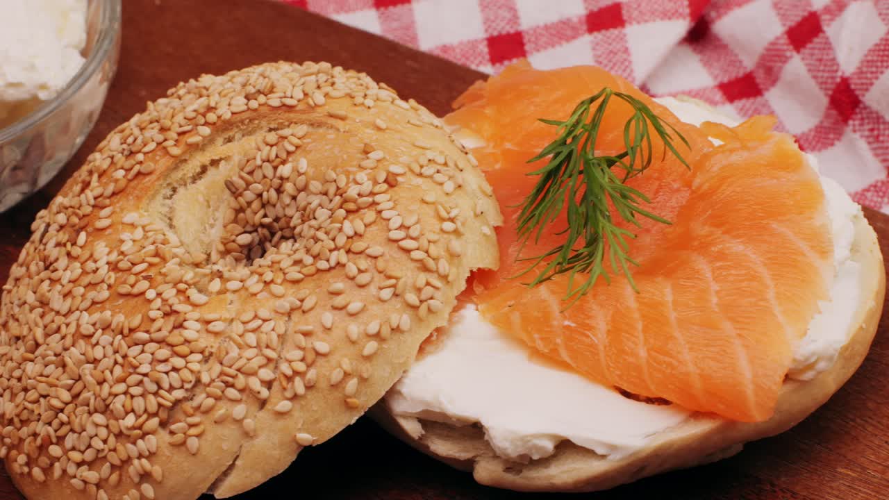 Bagel sandwich brunch, lunch plate of a bagel with smoked salmon and cream cheese and ham, close up morning cafe menu.