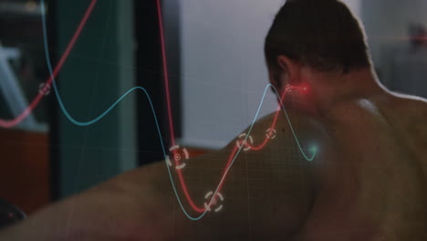 shirtless male athlete monitoring ar chart in gym, displaying red blue lines with circular markers