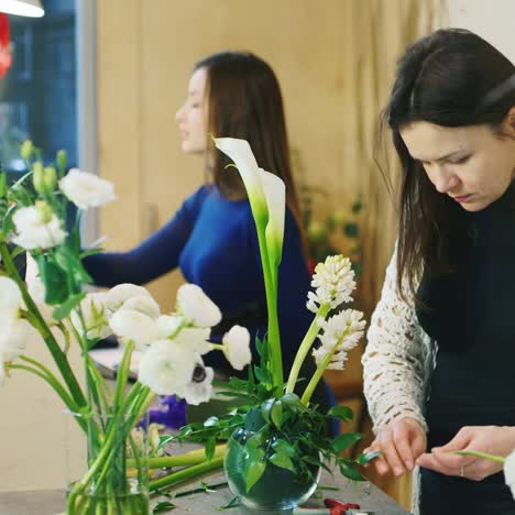 dos mujeres trabajan en una floristería