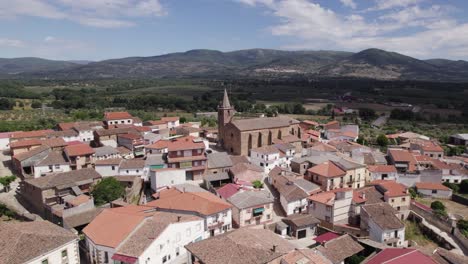 Pintoresco-Español-Tejeda-De-Tietar-Paisaje-Montañoso-Que-Orbita-La-Iglesia-Local-En-El-Tradicional-Paisaje-Urbano-De-Ladrillo-Rojo