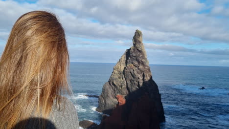 hermosa foto de una mujer admirando una de las formaciones rocosas de uno de los acantilados de la llamada ponta de são lorenzo, en la isla de madeira, portugal