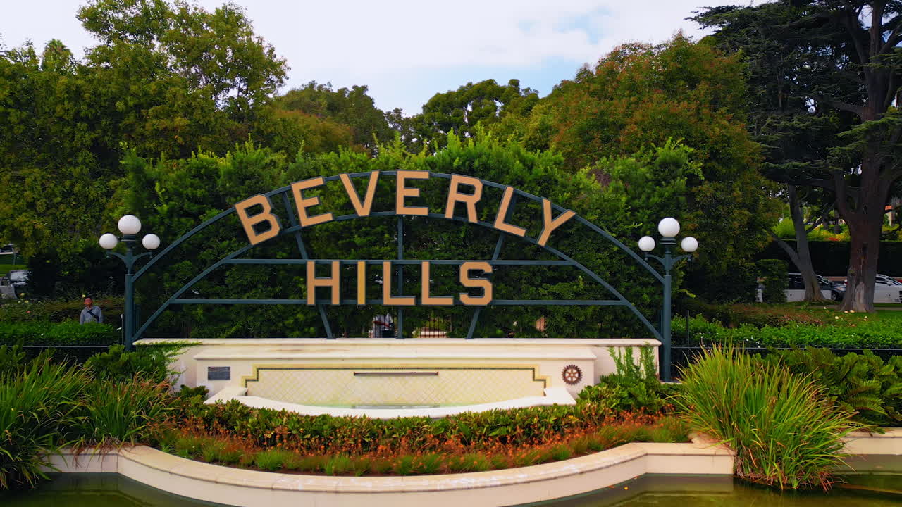 Los Angeles, USA, 29 August 2025: Approaching the signboard of Beverly Hills over the pond with lotuses. Beverly Gardens Park in California, USA