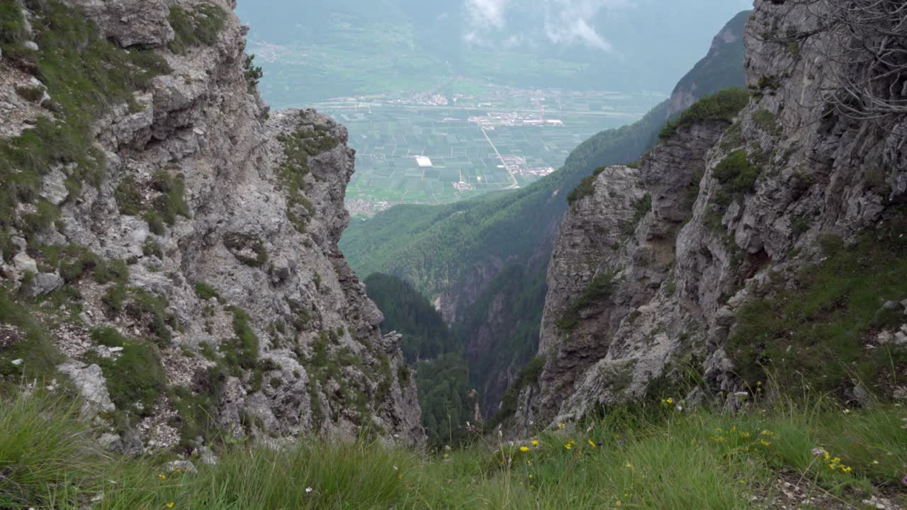 View through the rocks of the Mendel towards Neumarkt in the South Tyrolean lowlands on a nice day in summer.