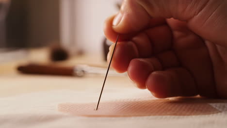close-up of a hand holding a needle
