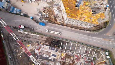 Bird&#039;s-eye view of active construction zone beside a busy road with vehicles and adjacent developments - Gdańsk