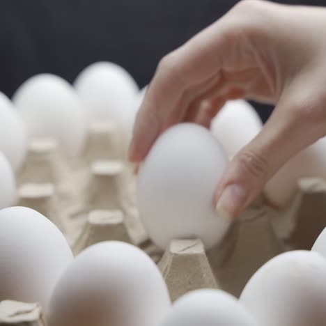 eggs are getting put into carton tray. crates of fresh eggs at a poultry farm.