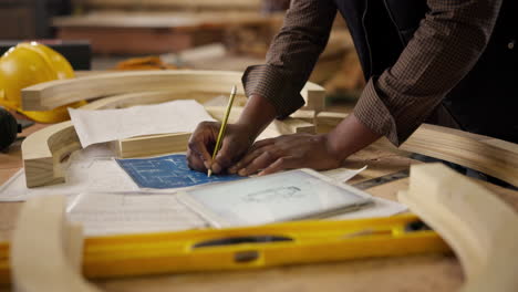 carpenter working on a blueprint with a tablet