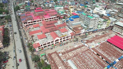 toma aérea de drones del mercado ima rodeado de edificios, automóviles, personas, puentes y más en india