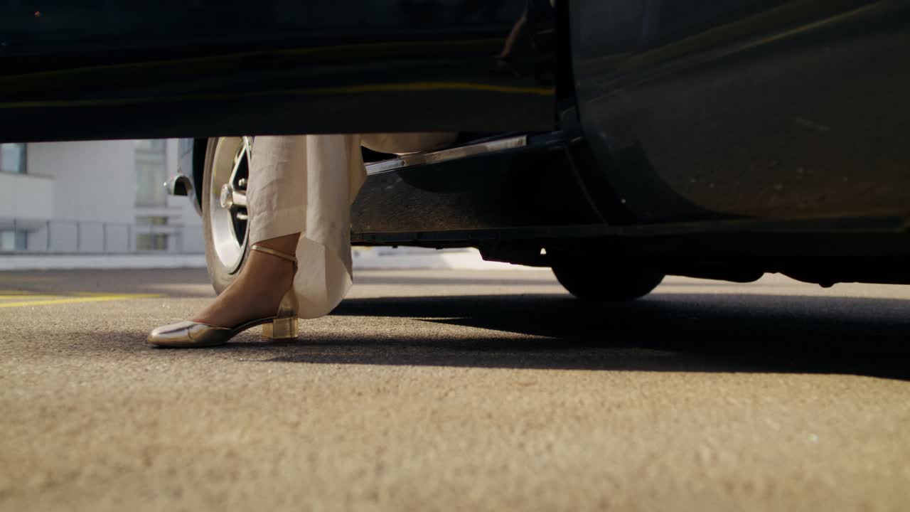 Woman getting out of a vintage car