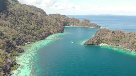 aerial pan drone shot of turquoise lagoons, and limestone cliffs and paraw boats, at a paradise isle, on a sunny day, at coron island, philippines, asia