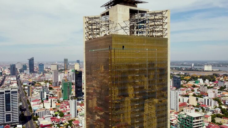 Phnom Penh city highrise buildings reflected in golden glass facade of a modern skyscraper, Gold Tower 42 exterior aerial closeup