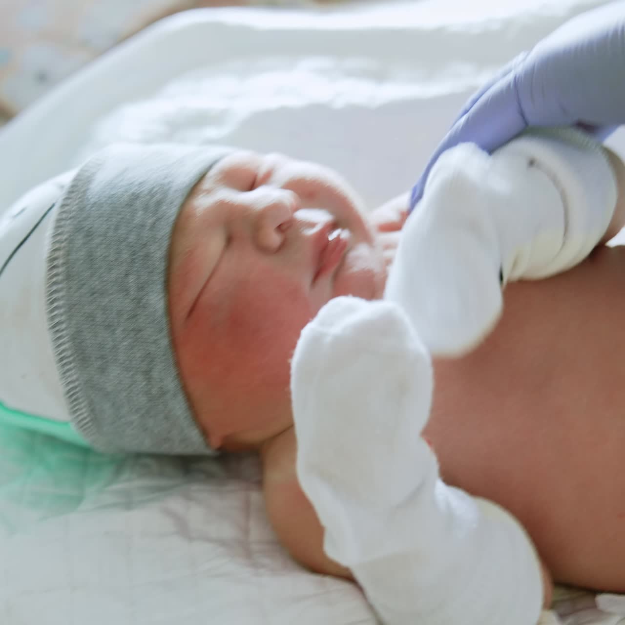Neonatologist is listening to a baby heart. The kid is unhappy about the check up. Close up
