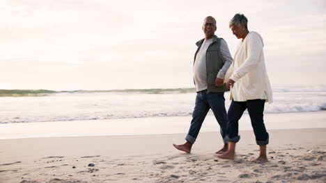couple, walking and holding hands on the beach