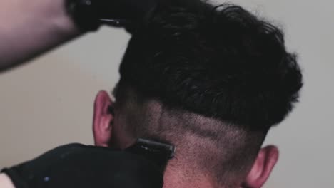 las maquinillas eléctricas se utilizan para cortar el pelo de un cliente masculino en una barbería