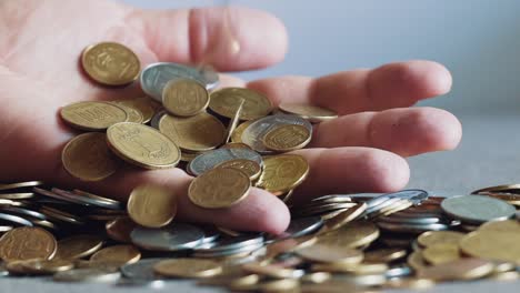 Lot of coins in the hands of men, symbolizing wealth. Slow motion