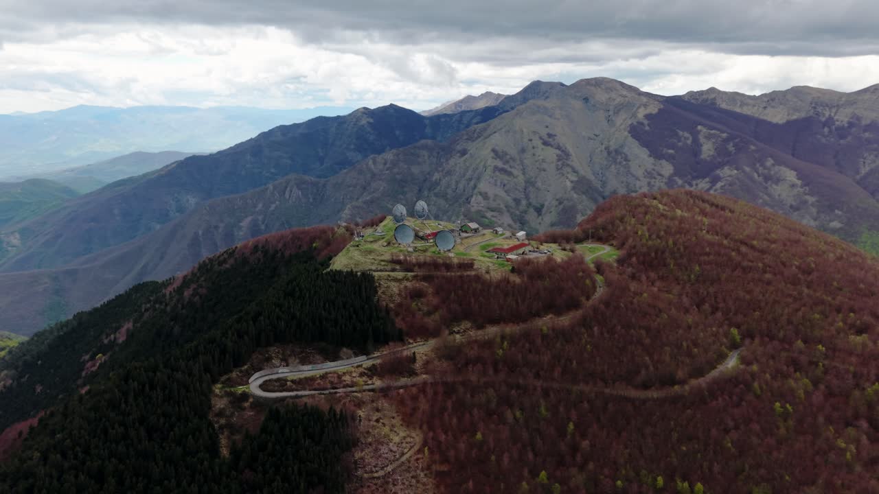 Old radar station on mountain peak, aerial view with cloudy sky and remote mood