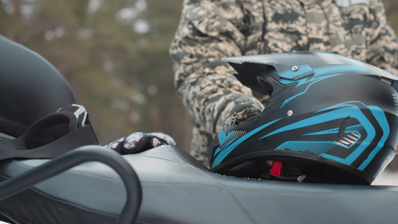 Individual checks helmet fastening before starting adventurous offroad journey. Careful safety inspection performed by rider before embarking on rugged offroad adventure with confidence