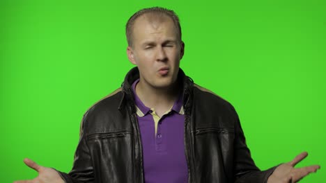 hombre rocker molesto levantando las manos en ira y gritando qué, por qué, cómo, peleando por problemas