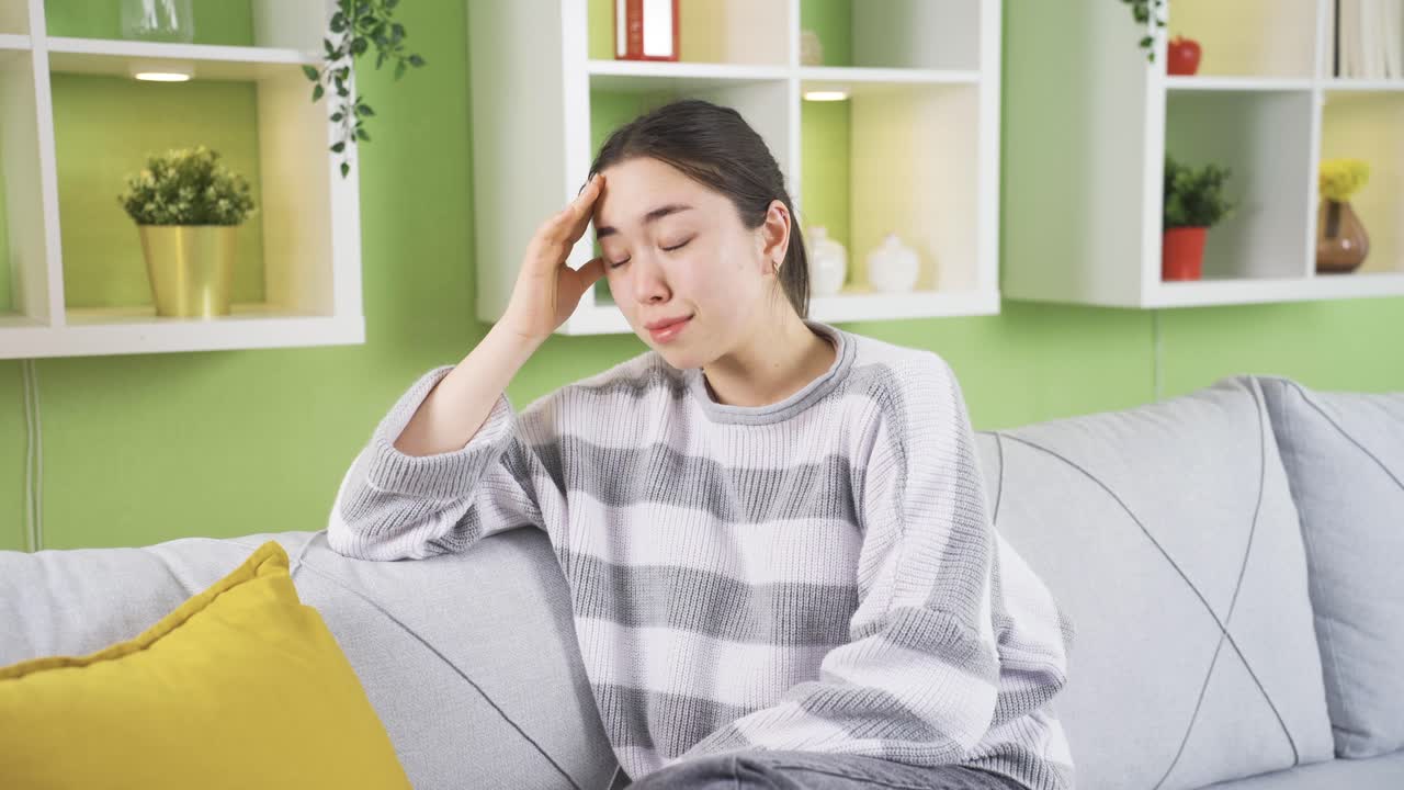 전화로 헤어짐 메시지를 받은 젊은 아시아 여성은 슬프고 우울하게 울고 있습니다.