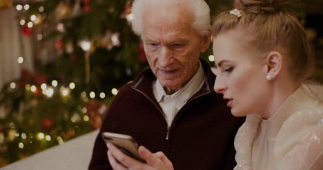 abuela enseñando a usar el teléfono celular en navidad