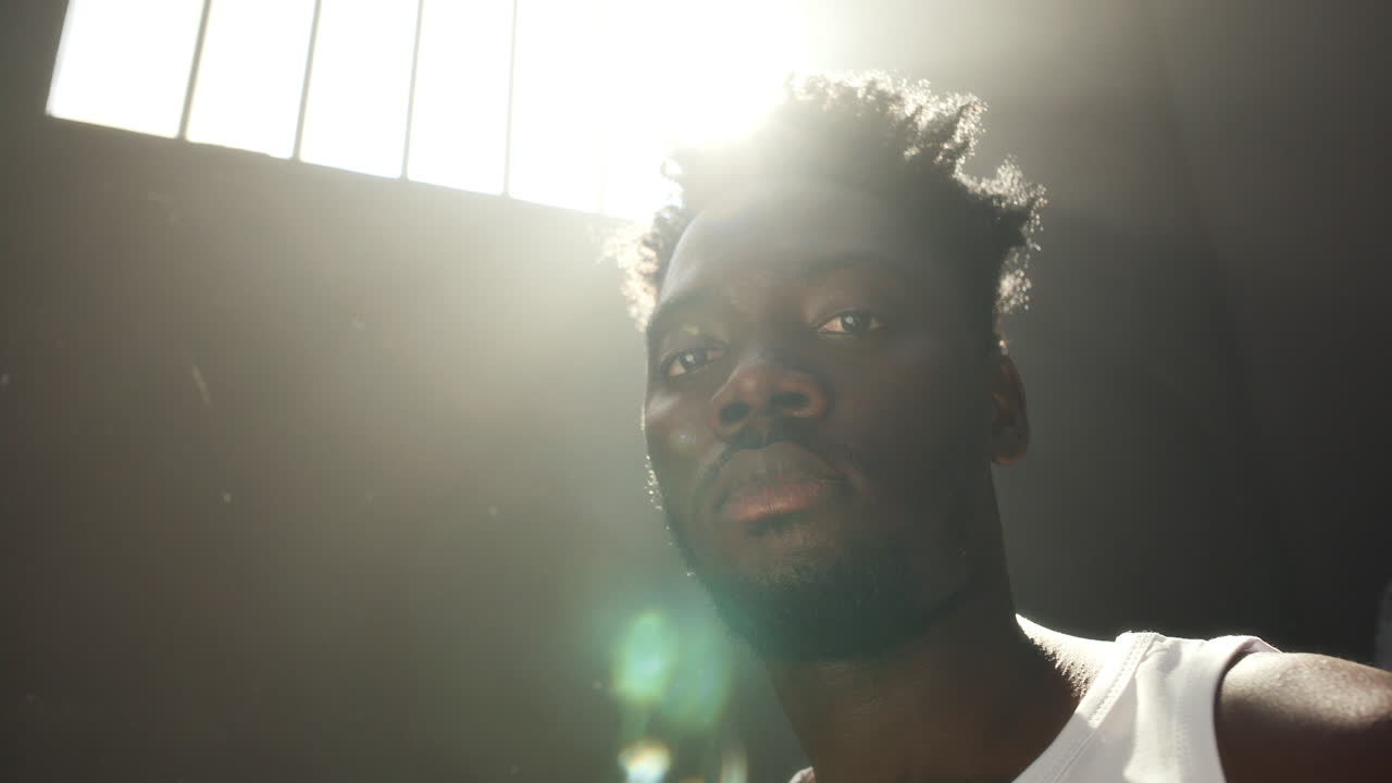 Portrait of Inmate under Sunlight Shining through Barred Prison Window