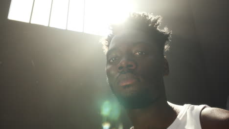 portrait of inmate under sunlight shining through barred prison window